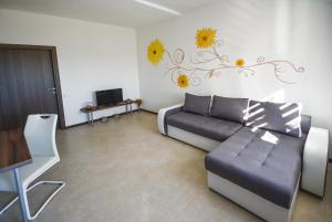 a living room with a couch and flowers on the wall at Apartments Bertetić in Kanfanar