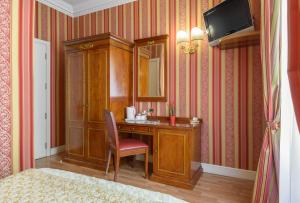 a room with a desk with a mirror and a chair at Gambrinus Hotel in Rome +45 photos