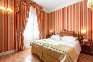 a bedroom with a large bed with red wallpaper at Gambrinus Hotel in Rome
