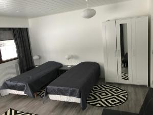 a bedroom with two beds and a mirror at Guesthouse Julia in Kajaani