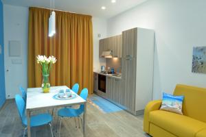 a living room with a table and a yellow couch at Appartamento Nonna Lina in Custonaci