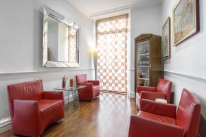 a waiting room with red chairs and a mirror at Gambrinus Hotel in Rome