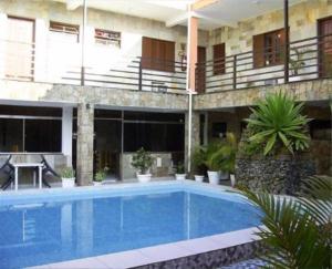 a swimming pool in front of a building at Hotel Alaska in Peruíbe