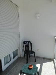 a black chair sitting on a patio with a table at Hospedaria Descansa Pernas in Monchique