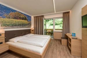 a bedroom with a bed and a large painting on the wall at Pension Irma in Caldaro