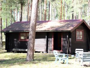 uma cabana de madeira com uma mesa e cadeiras à sua frente em Byron em Rälla