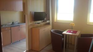 a small kitchen with a table and a television at Pension Fürst Borwin in Markgrafenheide