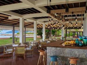 ein Restaurant mit einer Bar mit Tischen und Stühlen in der Unterkunft Six Senses Zil Pasyon, Seychelles in Felicité