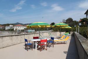 a group of tables and chairs with umbrellas at Hotel La Marinella in Castiglioncello