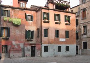 ein altes Gebäude mit grüner Wäsche davon in der Unterkunft Fiore della Laguna in Venedig