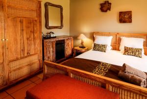 1 dormitorio con 2 camas y espejo en N'taba River Lodge & Spa en Port St Johns