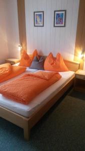 1 Schlafzimmer mit 2 Betten mit orangefarbener Bettwäsche und Kissen in der Unterkunft Haus Mary in Russbach am Pass Gschütt