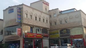 a group of buildings on a city street with cars at Aman Furnished Apartments 2 in Jeddah