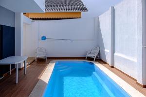 a pool in a room with a table and chairs at Sunset Holiday Home in Fernao Ferro