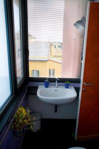 een badkamer met een wastafel en 2 ramen bij Piume Verdi in Genua
