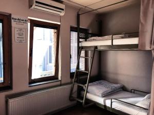 a room with three bunk beds and a window at ODA Hostel in Prishtin&euml;