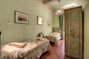 1 Schlafzimmer mit 2 Betten und einem Kronleuchter in der Unterkunft Pergola Apartment in Florenz