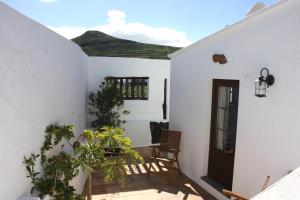 a room with white walls and a door and plants at Casa Rural "La Molina" in Máguez