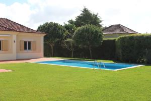 a swimming pool in a yard next to a house at Dunas Golf House in Cascais +96 photos