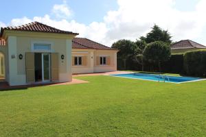 a house with a swimming pool in a yard at Dunas Golf House in Cascais