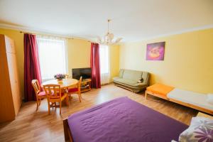 ein Wohnzimmer mit einem Bett und einem Tisch in der Unterkunft Medainie apartamenti in Liepāja