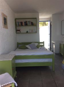 a bedroom with a green bed and a window at Rosys Little Village in Skala