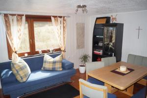 ein Wohnzimmer mit einem blauen Sofa und einem Tisch in der Unterkunft Ferienhaus Pension Fuchs in Neufra