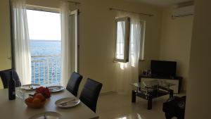 a dining room with a table and a view of the ocean at Apartments and Rooms Kod Mate in Tribanj-Krušćica