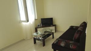 a living room with a couch and a glass table at Apartments and Rooms Kod Mate in Tribanj-Krušćica