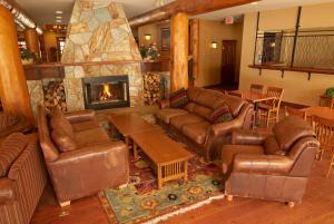 a living room with leather couches and a fireplace at Snow Creek Lodge by Fernie Lodging Co in Fernie
