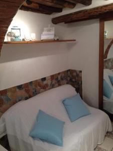 カポリーヴェリにあるAppartamento La Maisonのベッドルーム1室(青い枕2つ付きのベッド1台付)
