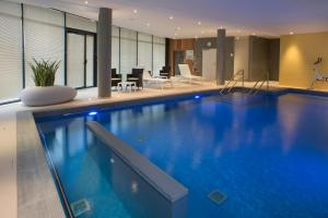 a large swimming pool in a hotel room at Domitys - Le Carillon d'or in Maubeuge