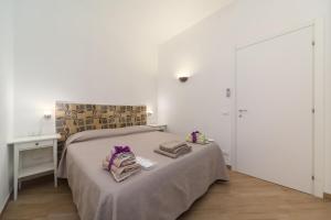 a bedroom with a bed with two towels on it at Ai Due Cortili in Trapani