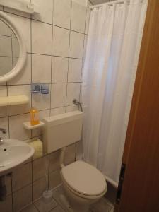 uma casa de banho com um WC branco e um lavatório. em Guest House Pavkovic em Slano