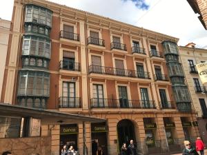 un gran edificio con gente caminando delante de él en AIRVA: Apartamento Teresa Gil, en Valladolid