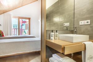 a bathroom with a sink and a bed at Cestaria Costa Nova in Costa Nova