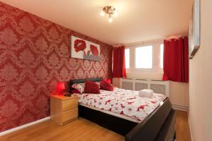a small bedroom with a bed with red walls at Victoria Centre Apartments in the Victoria Centre Shopping Centre - Nottingham City Centre - 24 hour access - Most Central Location, Kitchen - Sunday check-out 1pm - Opposite Hilton by Restaurants & Shops - Outdoor Parking Cars or Vans five pounds a day in Nottingham