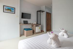 two stuffed animals sitting on a bed in a room at Lada Krabi Express in Krabi