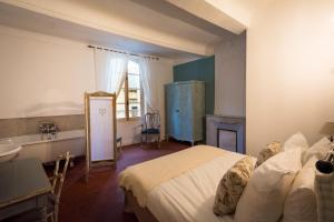 um quarto com uma cama, um lavatório e uma lareira em Les Chambres De Charlotte em Cucuron