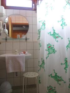 a bathroom with a shower curtain with a frog on it at Hotel Glück in Ebersbach an der Fils