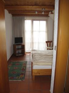 a bedroom with a bed and a tv and a window at Hotel Glück in Ebersbach an der Fils