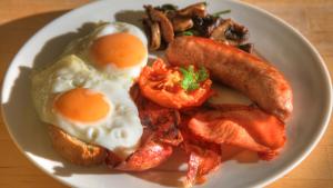 a plate of breakfast food with eggs bacon and tomatoes at Ashdowns of Dover in Dover