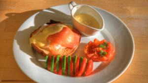 a white plate with a sandwich and a cup of sauce at Ashdowns of Dover in Dover
