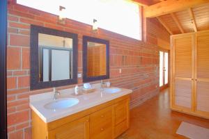 a bathroom with two sinks and a brick wall at Rancho El Rossinyol in Valle de Guadalupe