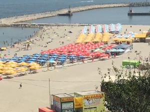 - une plage avec des parasols et des personnes sur le sable dans l'établissement Villa Anticus (Adults Only), à Constanţa