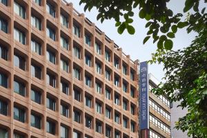 un edificio marrone con un cartello di fronte di Royal Inn Taipei Nanxi - MRT Zhongshan Station a Taipei