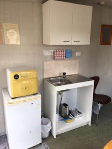 une petite cuisine avec évier et comptoir dans l'établissement Avondale Motor Park, à Auckland