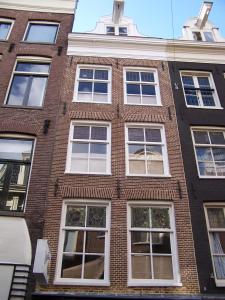 a brick building with white windows on a city street at Bed & Breakfast The 9 Streets in Amsterdam