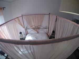 a bedroom with a canopy bed with white sheets at B&B Al Fronte del Porto in Genova