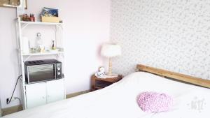 a bedroom with a white bed and a microwave at B&B A la Ferme d'Ourches in Cerville